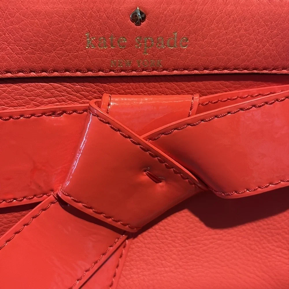 Kate Spade wristlet  pebble leather/patent bow on front  orangeish red gold NWOT
